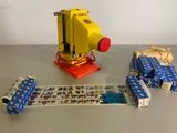 a yellow machine with a red handle next to several wrapped presents