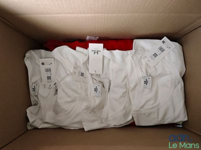 a box full of white t - shirts with tags on them