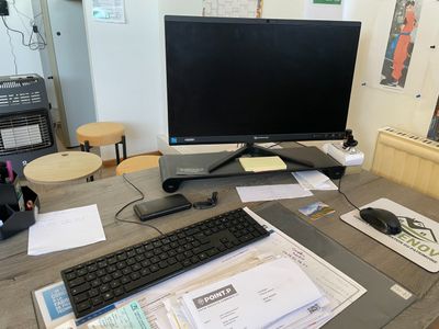 un bureau sur lequel se trouvent un écran d'ordinateur, un clavier, une souris et d'autres objets