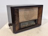 une radio à l'ancienne posée sur une table blanche