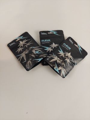 trois paquets de cigarettes noires et blanches posés sur une table blanche