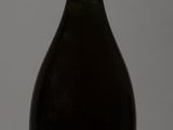 bottle of champagne on a white table with a gray background