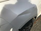 a shadow of a person on the side of a white car