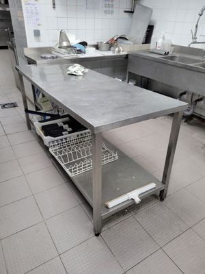 une cuisine équipée de plans de travail en inox et d'un lave-vaisselle