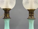 pair of green glass lamps with etched designs on the bases