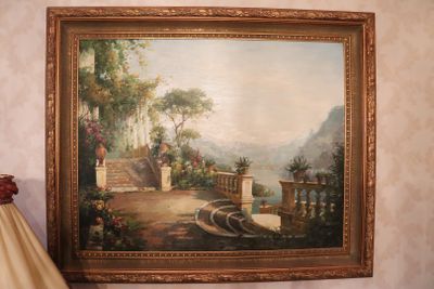 a painting hanging on the wall next to a lamp
