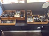 a lot of forks and spoons in a wooden box