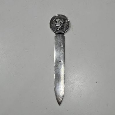 a small metal object with a coin on top of it