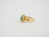 a gold ring with an emerald stone and diamonds