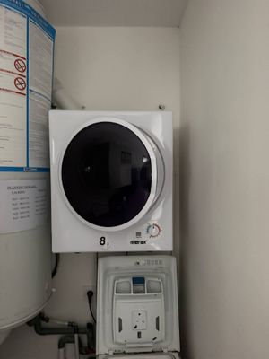 une photo d'un lave-linge et d'un sèche-linge dans une petite pièce