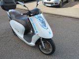 a scooter that is parked on the side of the street