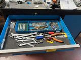 a drawer full of tools on a workbench in a garage