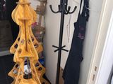 a yellow christmas tree that is next to a black coat rack
