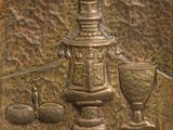 une plaque métallique sur laquelle est représentée une théière et des tasses