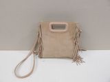 beige sued bag with fringes and a handle on a white surface