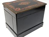 an old black wooden box with a red and gold design on it