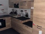 an image of a kitchen with wooden cabinets and black counter tops