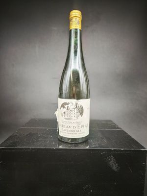 une vieille bouteille de vin posée sur une boîte noire