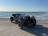 une voiture de collection garée sur la plage, près de l'océan
