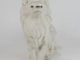 a white cat figurine sitting on a white surface