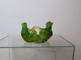 a glass display case with a green sculpture on it
