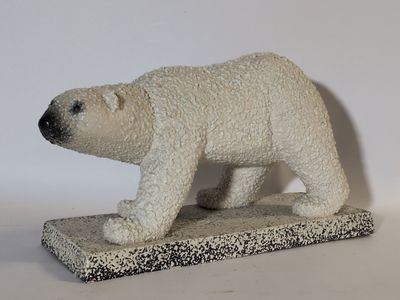 statue d'un ours polaire posée sur une surface blanche, avec un fond blanc