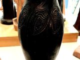 un vase noir posé sur une table dans une pièce