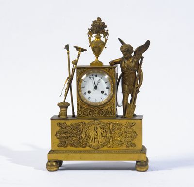 une horloge en or ornée d'anges et surmontée d'un vase