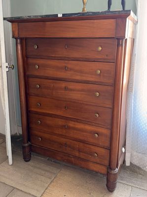 a wooden chest of drawers in the corner of a room