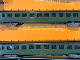 two green train cars on display on a yellow table