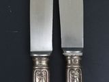 two knives that are sitting next to each other on a table