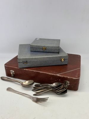 une pile de couverts posée sur une valise
