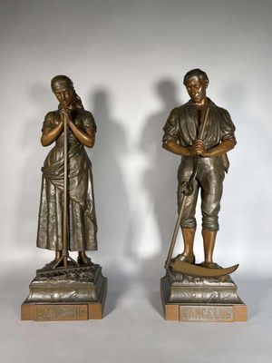 paire de statues en bronze représentant un homme et une femme, l'un tenant une canne