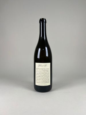an empty bottle of wine sitting on top of a white table