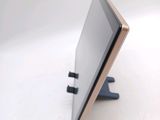 a tablet computer sitting on a stand on a white surface