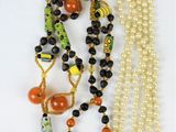 two necklaces with beads and beads on a white surface