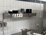 stainless steel counter top in a commercial kitchen with pots and pans on it
