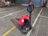 un chariot élévateur rouge garé au milieu d'un parking