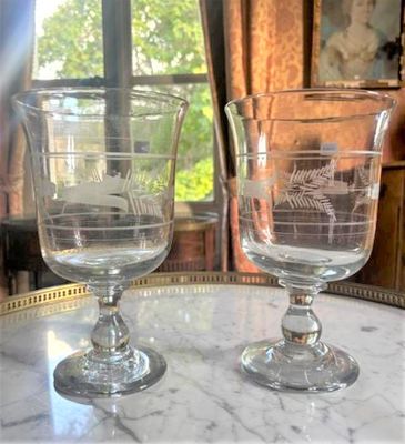 deux verres à vin posés sur une table devant une fenêtre