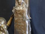 bronze statue of a woman kneeling next to a statue of a man