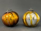 two glass ornaments that are sitting next to each other