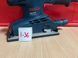 un gros plan d'une ponceuse orbitale Bosch posée sur une table