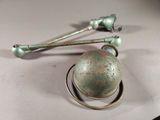 a metal ball and two metal spoons on a table