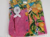 Le t-shirt est rose, avec des fleurs orange et bleues.