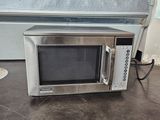 a microwave that is sitting on the floor next to a wall