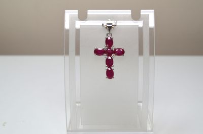 une petite croix rouge exposée dans une boîte transparente