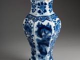 blue and white vase with a bird and flowers on it