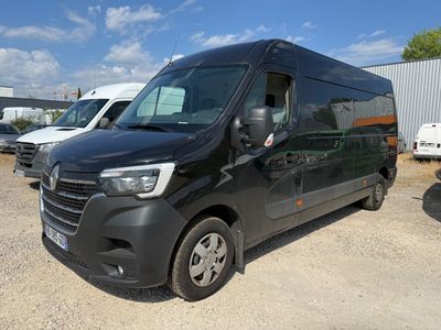 une camionnette noire garée sur un parking, avec d'autres véhicules en arrière-plan