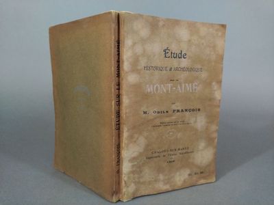an old book sitting on top of a table next to a gray wall