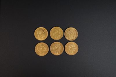 quatre pièces d'or posées les unes à côté des autres sur une surface noire